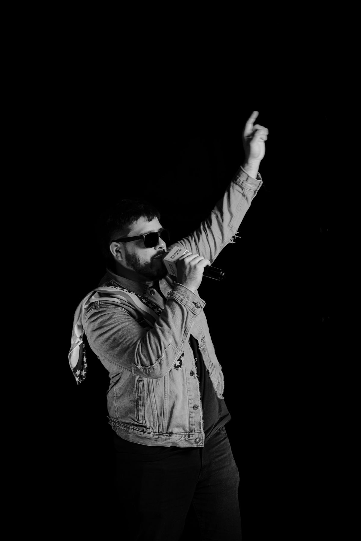 DJ Wolves performing with hand raised, black and white photo