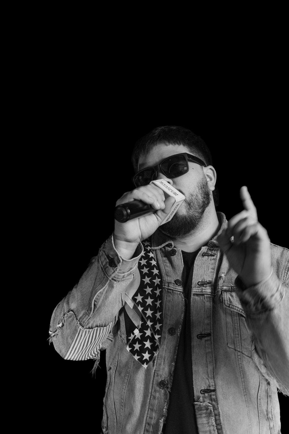 DJ Wolves speaking into a microphone, black and white photo